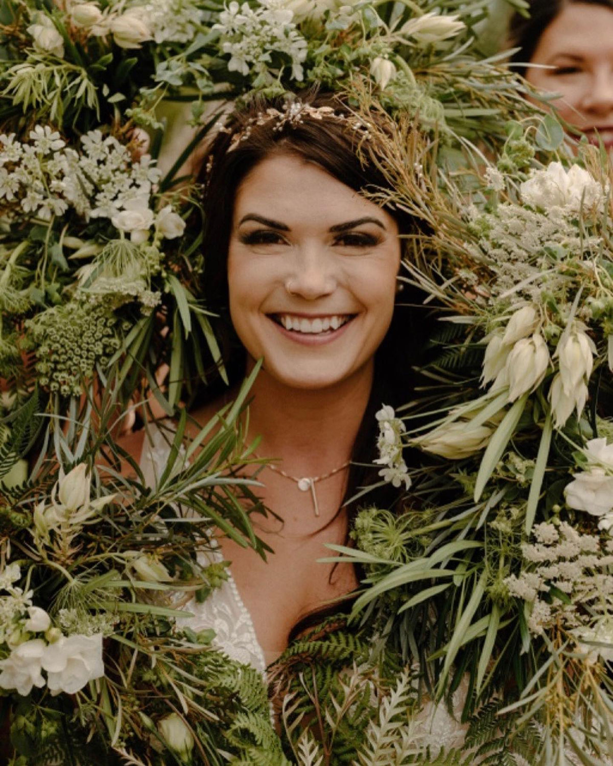 Wedding couple walking hand in hand after their ceremony, carrying an Aster and Bliss bouquet