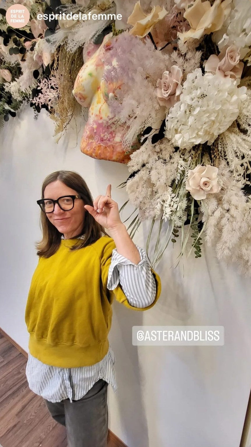 Floral designer Rebecca Scheller adding blooms to a hanging floral installation