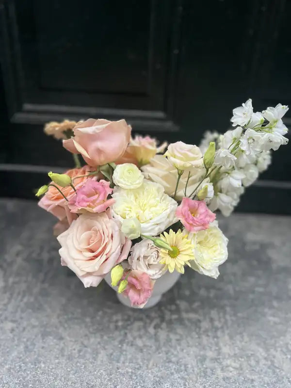 Blush and cream low wedding centerpiece with roses and stock