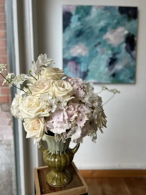 Hydrangea and rose arrangement in a green urn