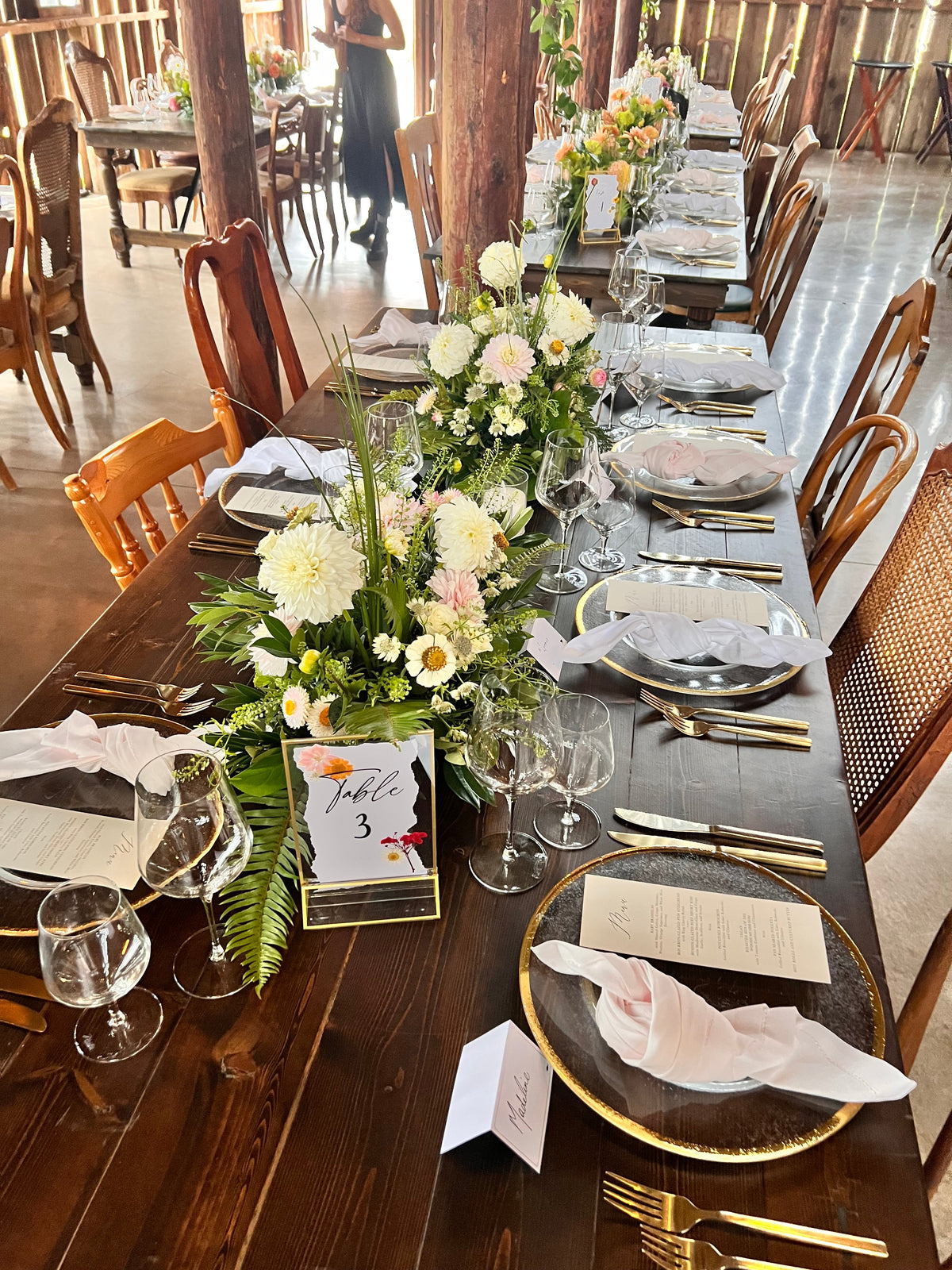 Long barn wedding reception table with dahlia and cosmos centerpieces